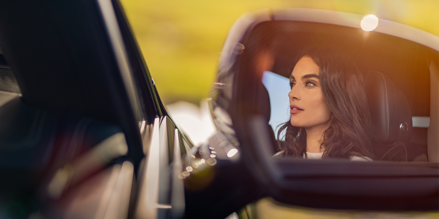 Bentley Paris Seine profile of dark haired woman's face in mirror of Bentley car in sunlight