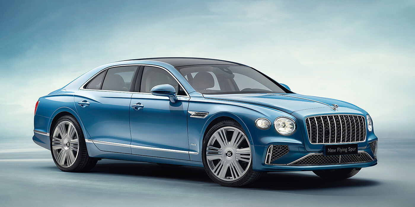 Bentley Paris Seine New Bentley Flying Spur Azure sedan front view in Light windsor blue by Mulliner paint with 22 inch Azure wheels and chrome exterior details