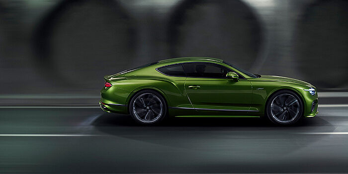  Bentley Paris Seine Bentley Continental GT coupe in Tourmaline Green paint driving in profile on a dark road