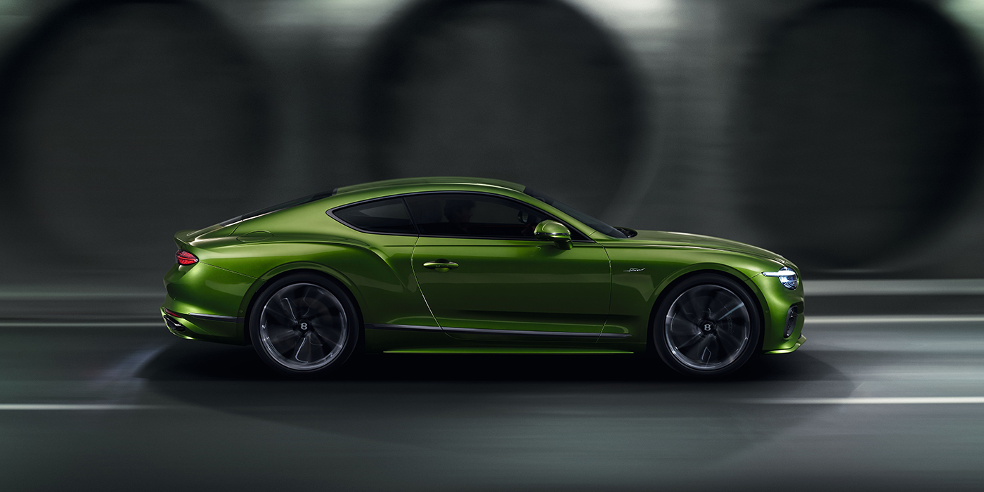 Bentley Paris Seine Bentley Continental GT coupe in Tourmaline Green paint driving in profile on a dark road