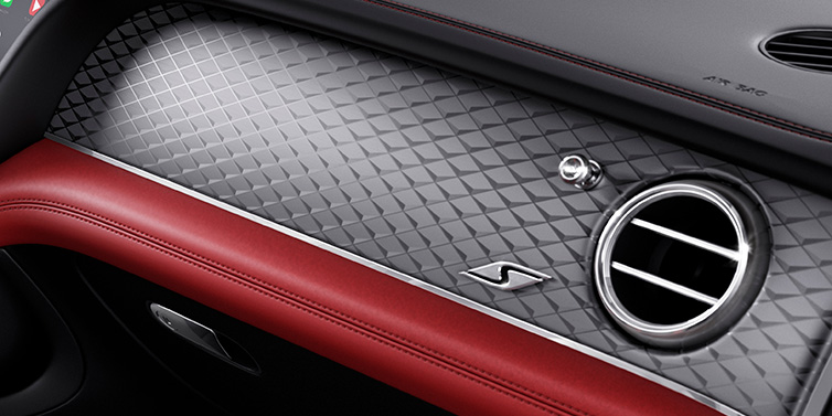 Bentley Paris Seine Bentley Bentayga S SUV front interior dash with Dark Tint Diamond Brushed Aluminium veneer and S badge surrounded by Hotspur red and Beluga black hide