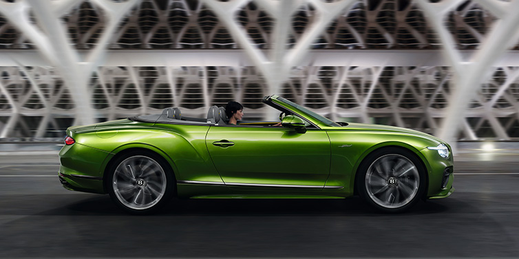 Bentley Paris Seine Bentley Continental GTC Speed convertible side profile in Tourmaline Green paint driving dynamically on a bridge at night