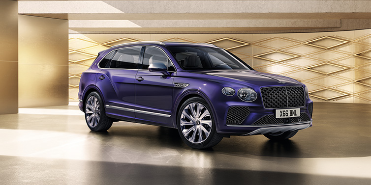 Bentley Paris Seine Bentley Bentayga Extended Wheelbase Mulliner SUV front three quarter in Tanzanite Purple paint with a gold patterned background