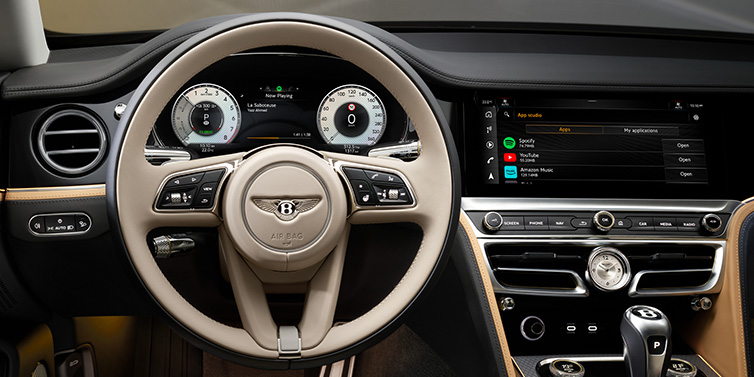 Bentley Paris Seine Bentley Flying Spur Mulliner sedan front interior detail of steering wheel and driver screens surrounded by Linen and Beluga black hides