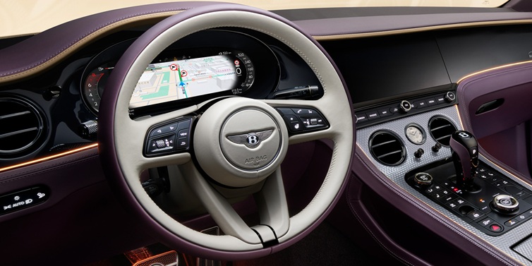 Bentley Paris Seine Bentley Continental GT Mulliner coupe front interior showing steering wheel and drivers screens surrounded by Linen and Damson hides and Grand Black veneer